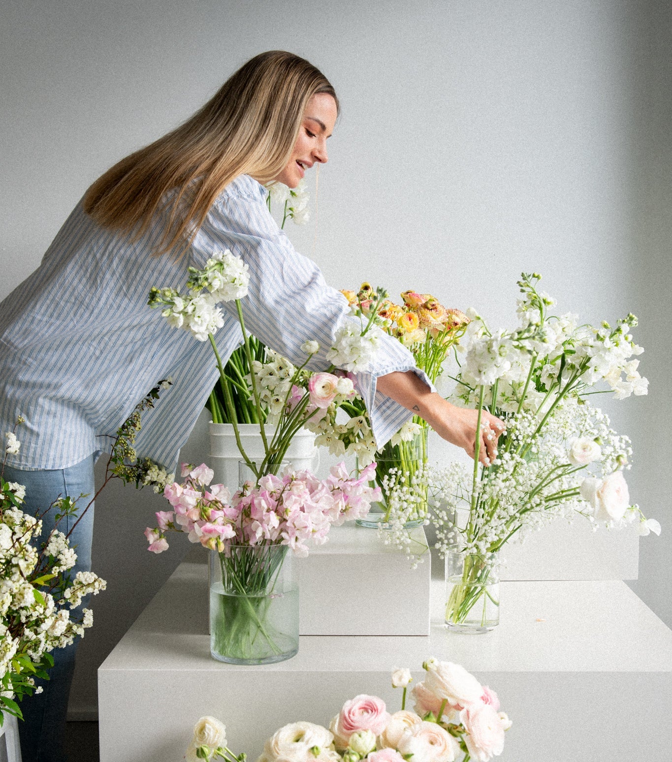 Woman arranging flowers in a home setting